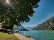 Die Anlegestelle Scholastika der Achenseeschifffahrt befindet sich in Achenkirch. Hier gleitet das Schiff bei schönem Wetter über den See. /// This photo shows the Scholastika pier of the Achenseeschifffahrt in Achenkirch, as one of the ships sails across the lake in bright sunshine.